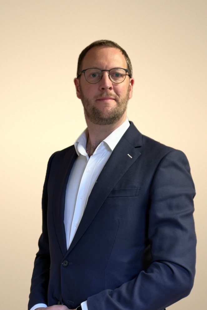 Luke Birch, founder and principal of PROSIMIɅN, in a dark jacket and open-collar shirt